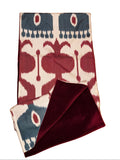Reversible artisan stole in crimson, indigo and ivory ikat with crimson velvet. Handcrafted Uzbek textile, 200×40cm. Vienna atelier.